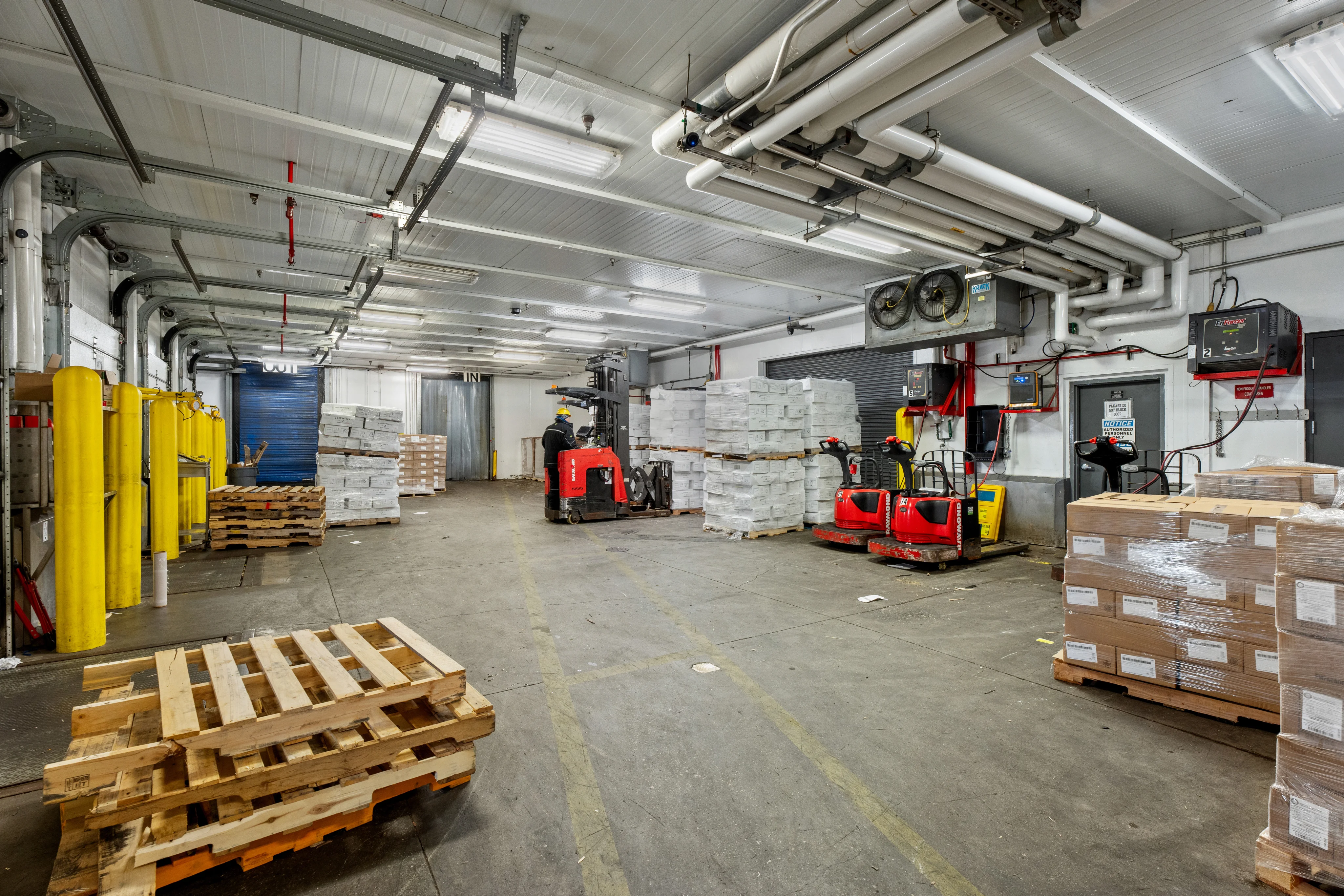Warehouse Worker Labeling and Wrapping Pallets